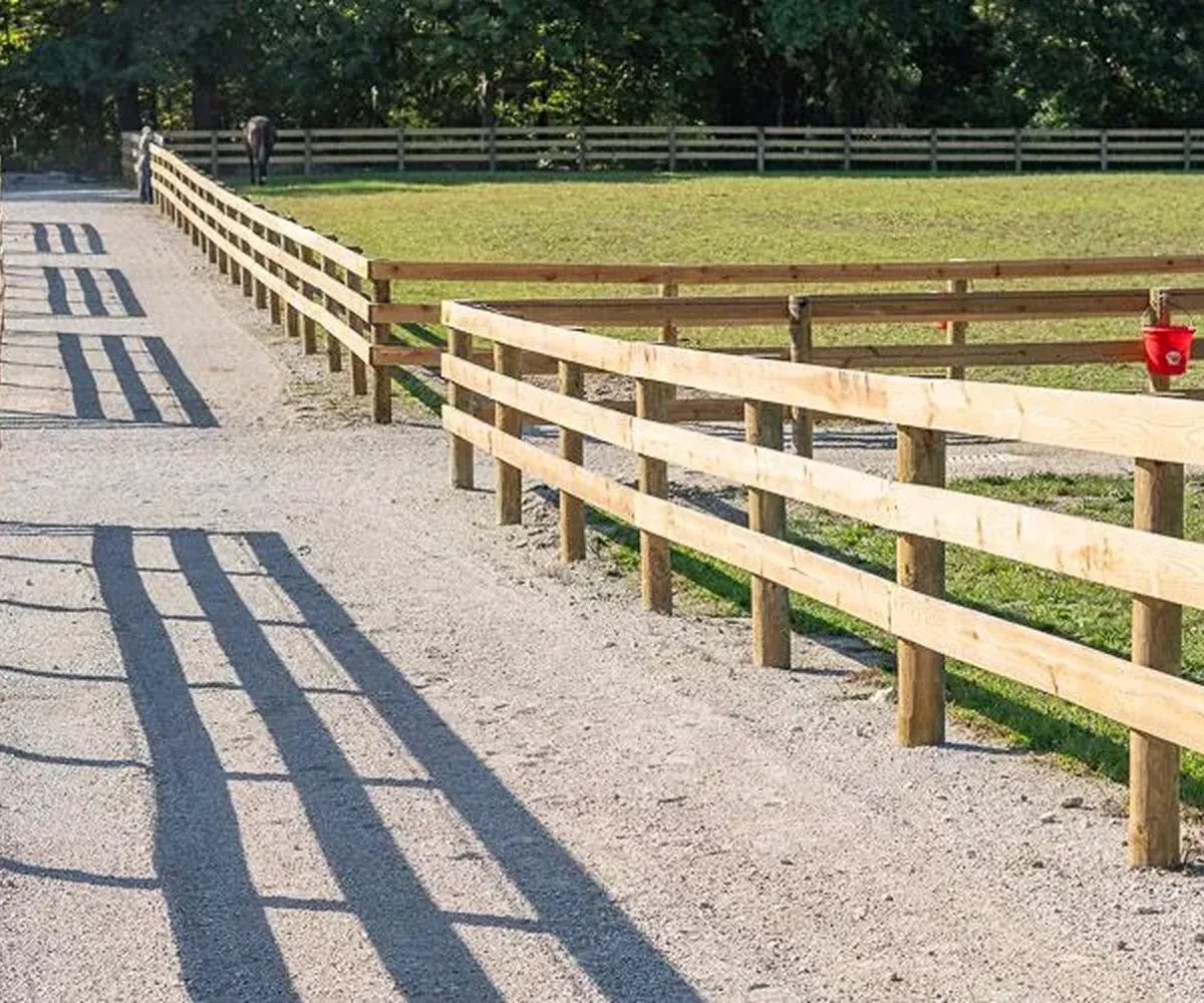 Board and wire fencing installed along a farm lane