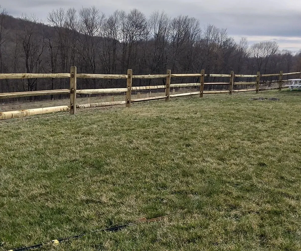 Split rail fence across an open field